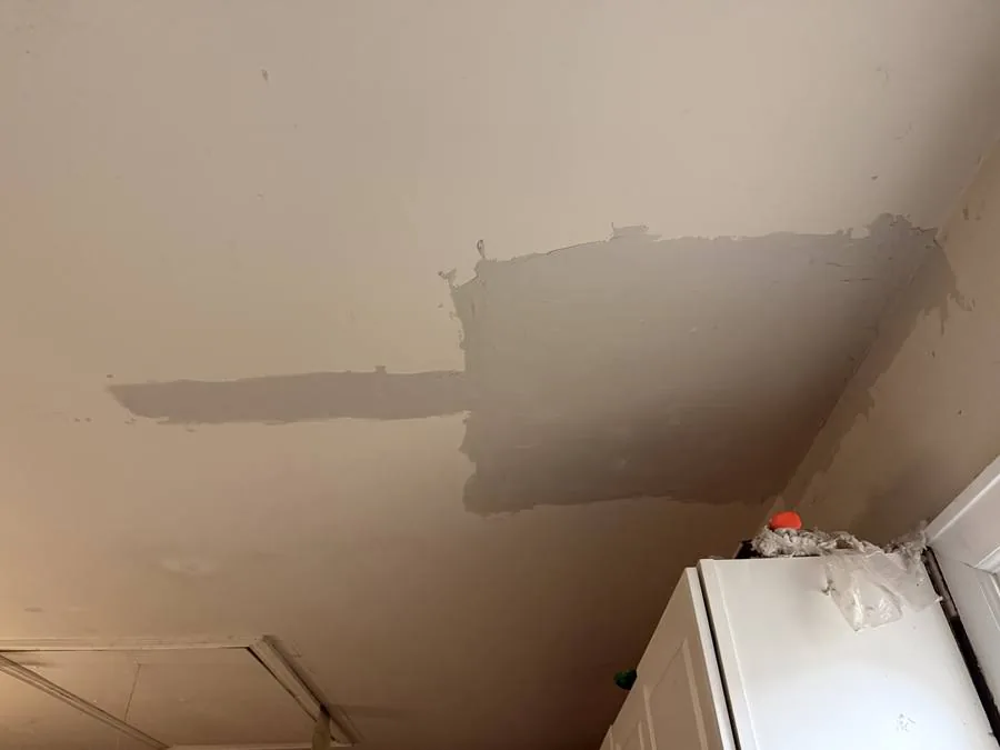 Ceiling mid-repair — new drywall installed, compound applied