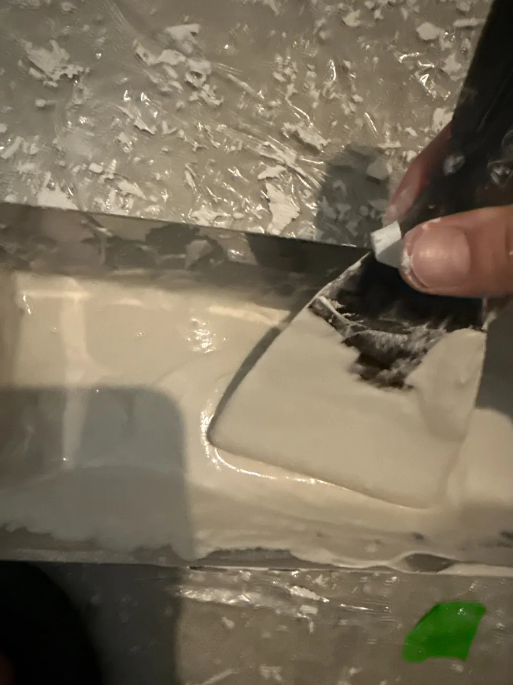 Drywall mud pan and knife used during texture repair